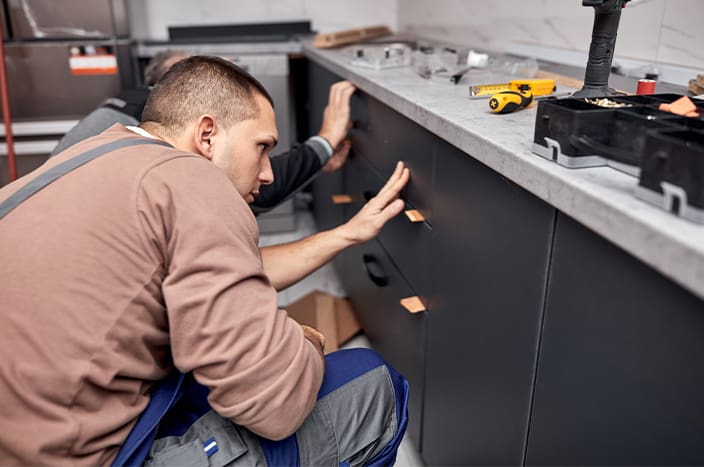 Engineers Inspecting Blueprint Of House Remodel With Client