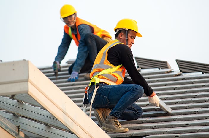 Roof repair,Construction worker using nail gun to install new roof on top roof